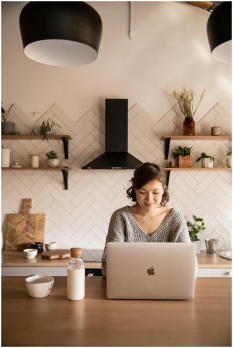 Young female student in gray sweater sitting at wo