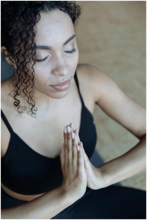 Close-up of a woman meditating indoors with eyes c