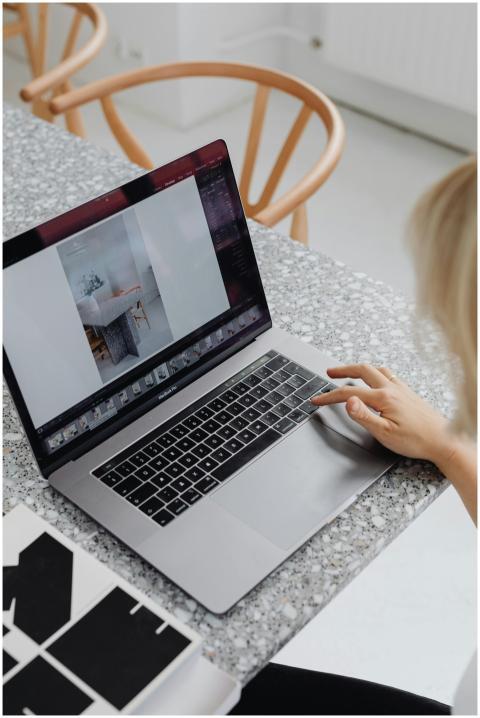 Overhead view of a woman using a laptop on a styli