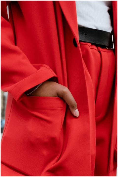 Close-up view of a red suit with a hand in the poc