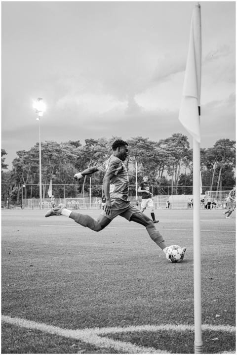 Black and white photo of a soccer player in mid-ai