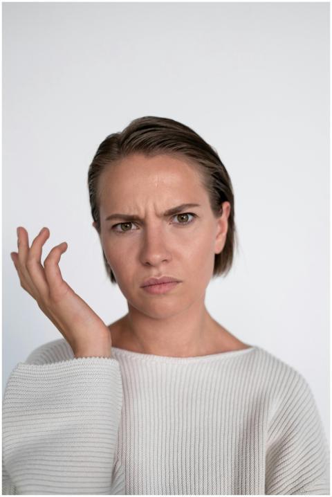A confused young woman with a questioning facial e
