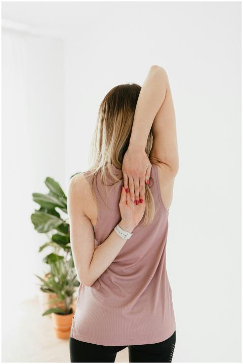 Back view of faceless young slender female warming