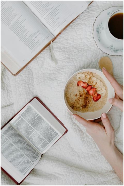 Flat lay of a cozy breakfast with oatmeal, books,
