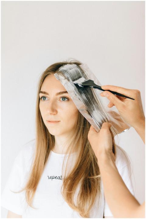 Woman getting blonde hair treatment in a salon wit