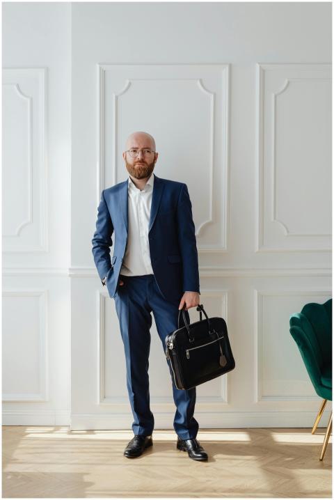 Bald businessman in blue suit holding a briefcase