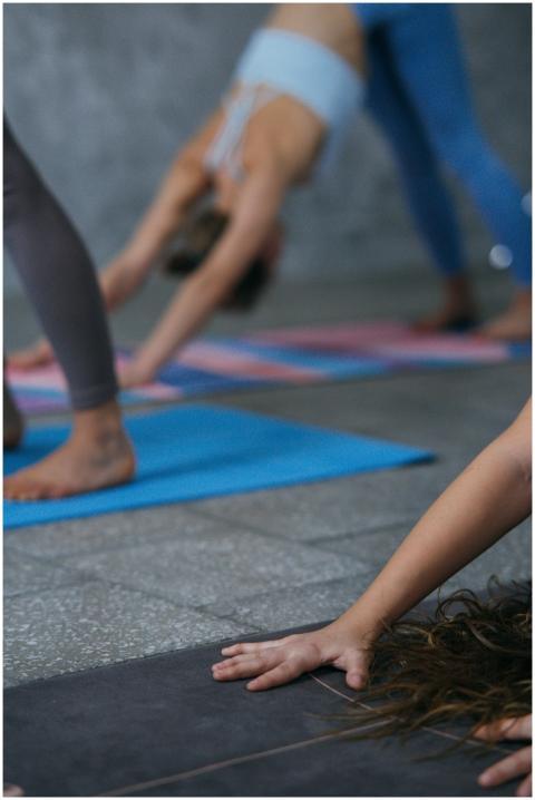 A group of women performing yoga poses on mats in