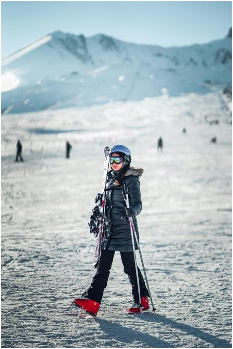An adult skier in winter gear on a snowy mountains