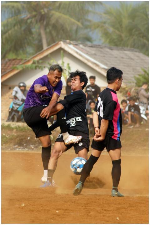 Competitive soccer game on a dusty field, capturin