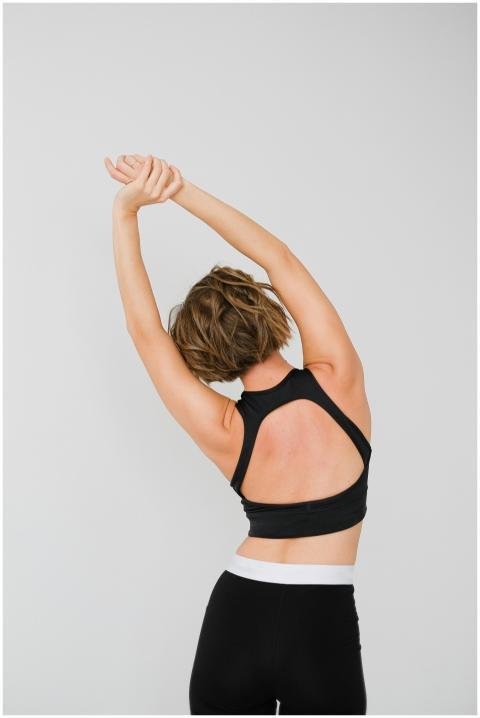 A woman in sportswear performs a stretching exerci
