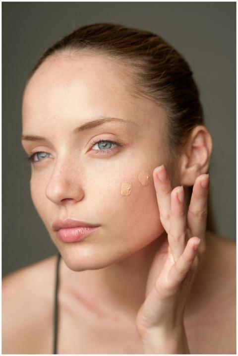 Close-up of a woman applying foundation, highlight