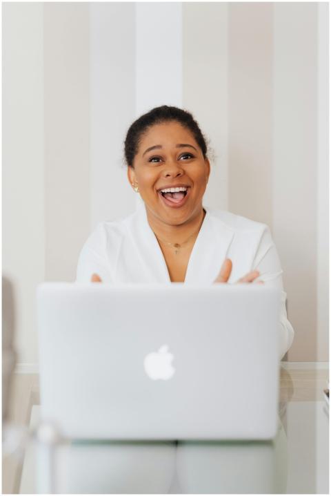 Happy black woman using a laptop at a modern offic