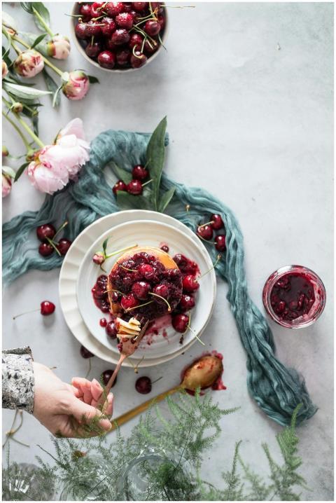 Flat lay of cherry pancakes with floral decor, ide