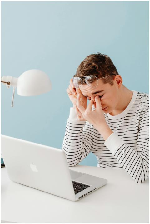 Teenager in striped shirt showing fatigue while si
