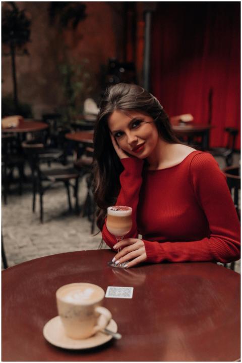 Brunette woman in red dress enjoying a coffee at a