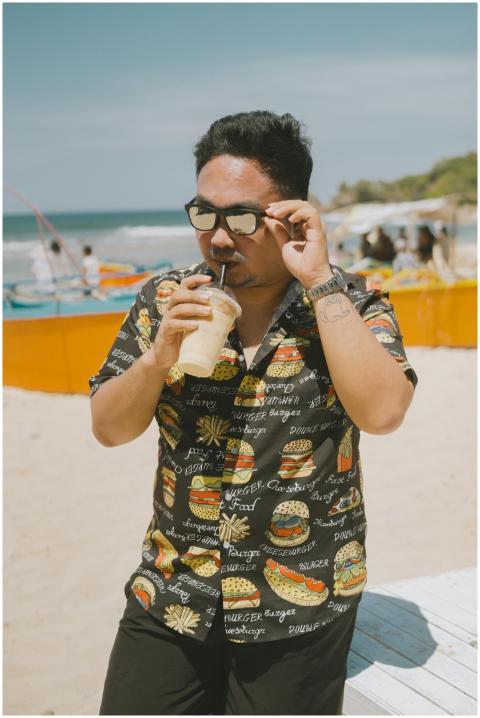 Man sipping a drink on Bolinao beach in sunny weat
