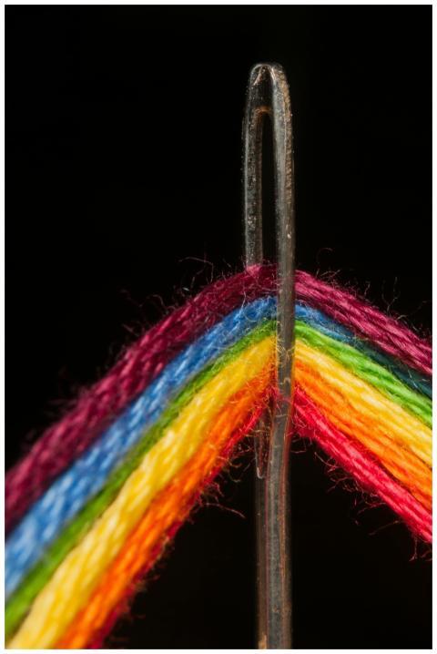 Vibrant close-up of a sewing needle threaded with