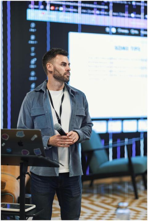 Man presenting at a business conference with digit