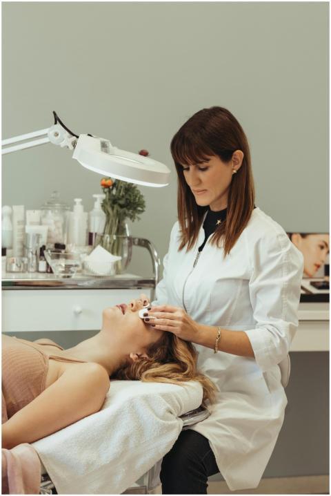 A cosmetologist performing skincare procedures on