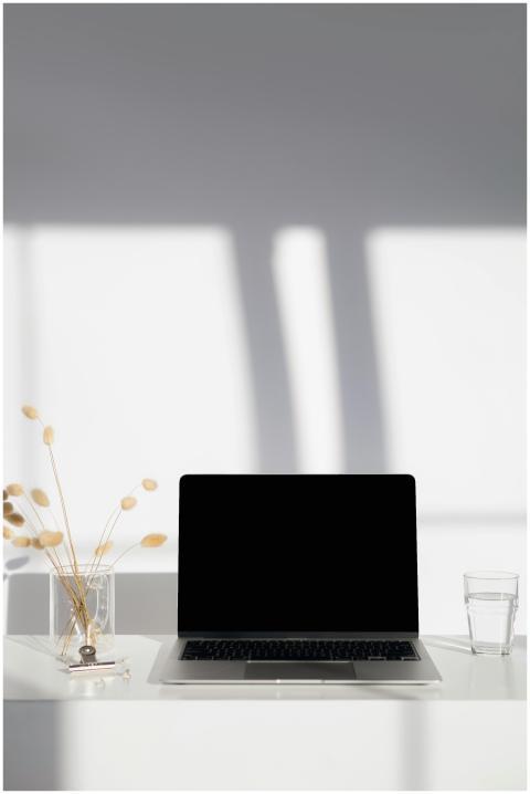 A clean and sunny minimalist workspace with a lapt