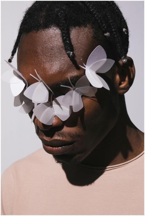 Artistic portrait of a man with paper butterflies