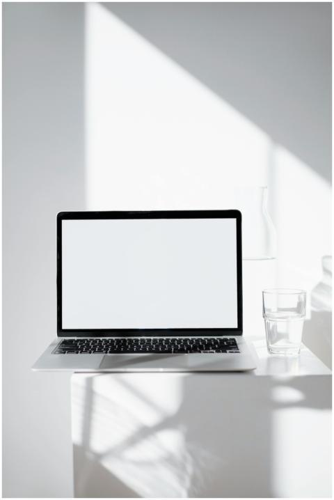 Minimalist workspace with laptop in natural light,