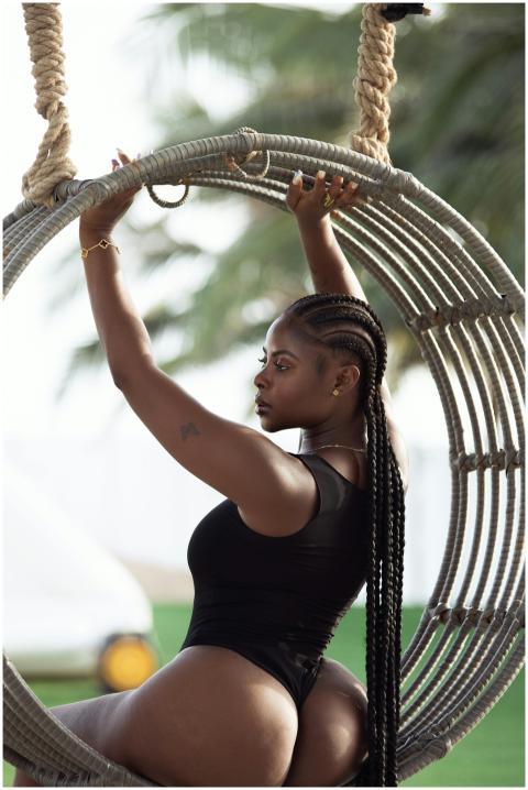 Beautiful woman in a black bodysuit sitting on a s