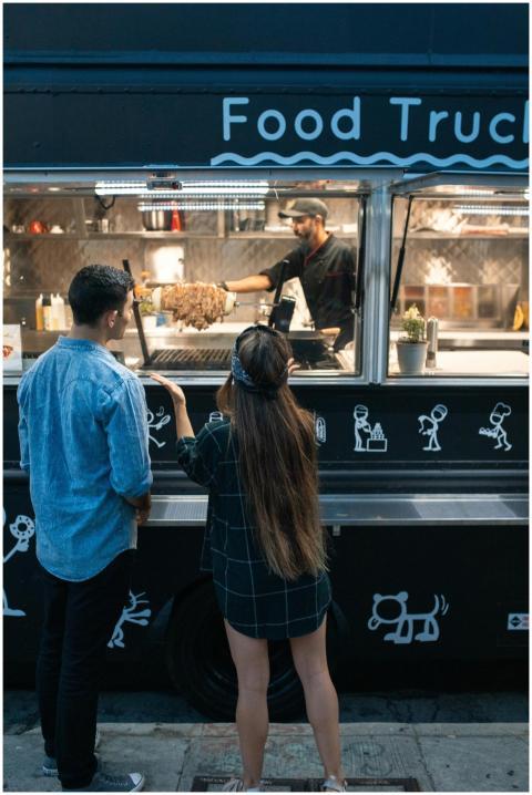 A couple ordering food at a lively street food tru