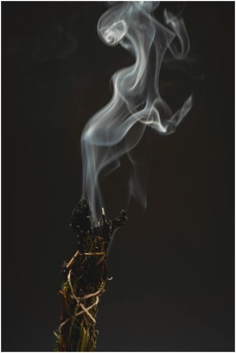 Ethereal smoke swirls from burning incense, creati