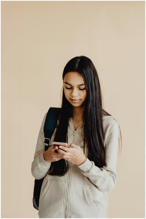 Teenage girl with long hair using a smartphone, we