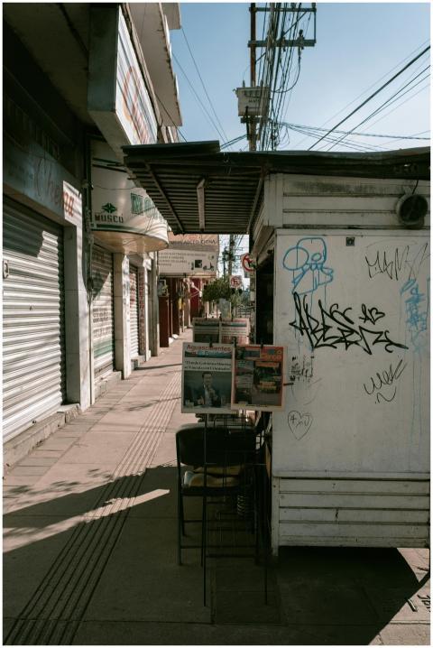 Urban street scene with graffiti-covered newsstand