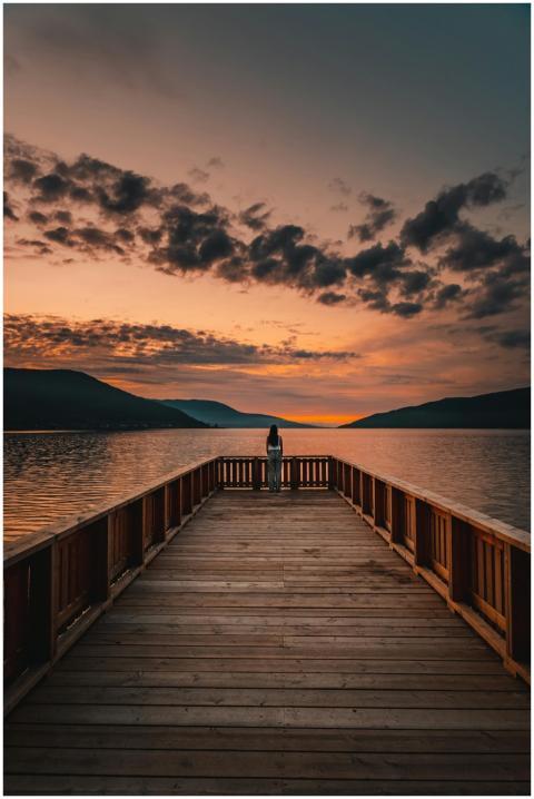 A tranquil sunset view from a wooden pier overlook