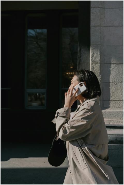Asian businesswoman walking outdoors in a trench c