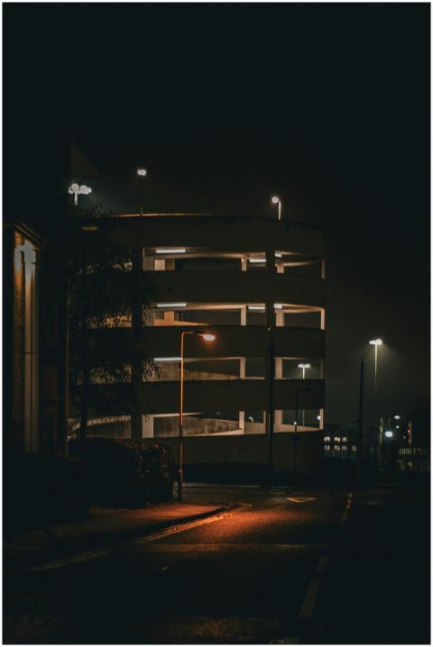 Eerie urban parking garage with street lights illu