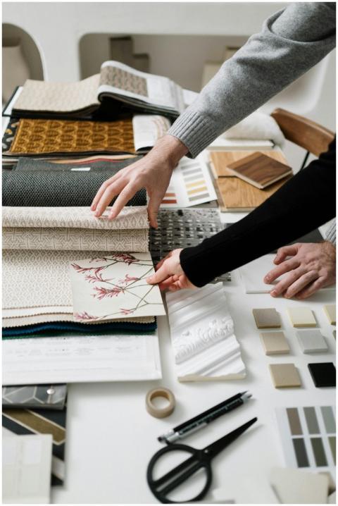 Close-up of hands selecting fabric patterns for in