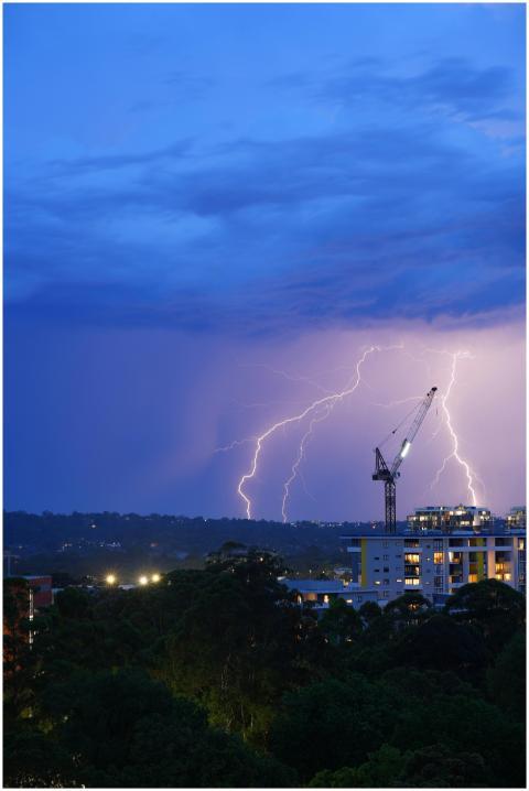 Lightning strikes illuminate a cityscape at night