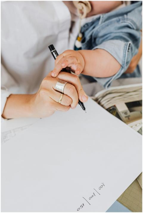 Close-up of a parent and child writing on paper to