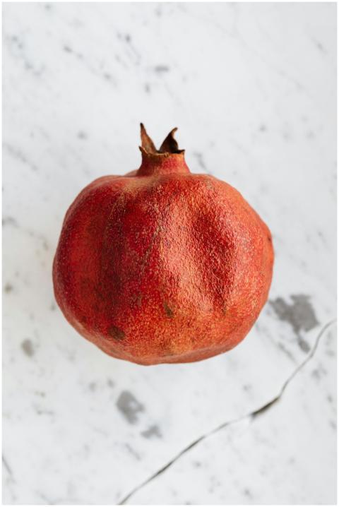 From above of whole ripe pomegranate with rough pe