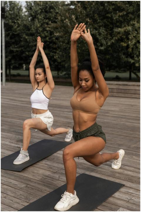 Two women practicing yoga in a park, displaying st