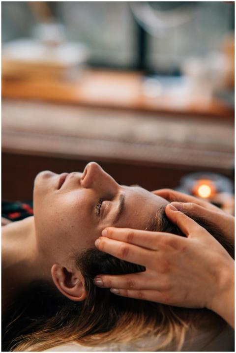 Woman enjoying a relaxing face massage indoors, ey
