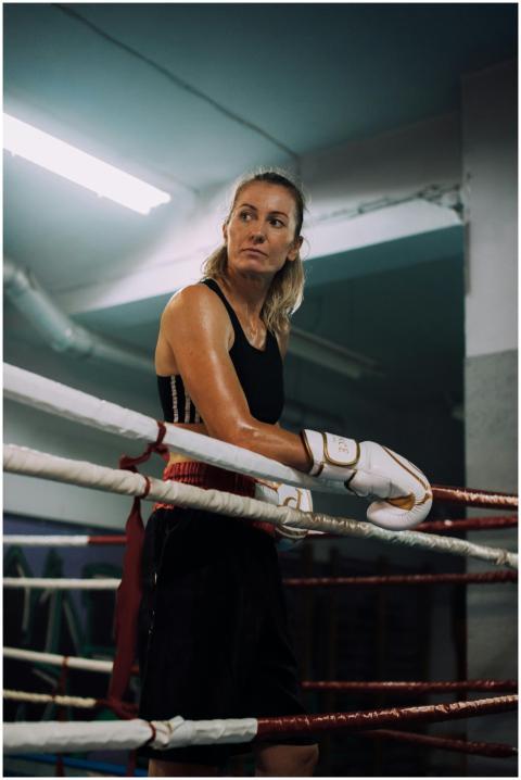Focused female boxer standing in a boxing ring dur