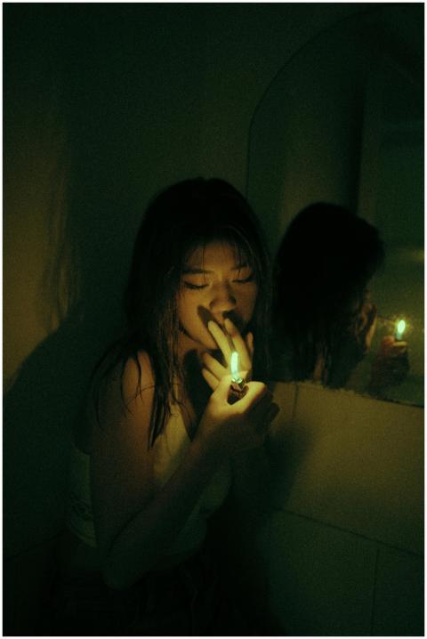 A dark and atmospheric image of a woman using a li