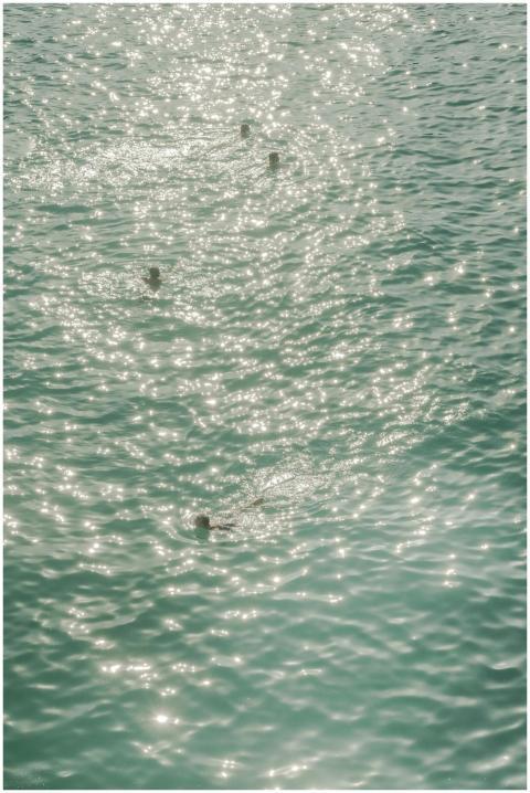 Aerial view of swimmers in a sparkling turquoise s