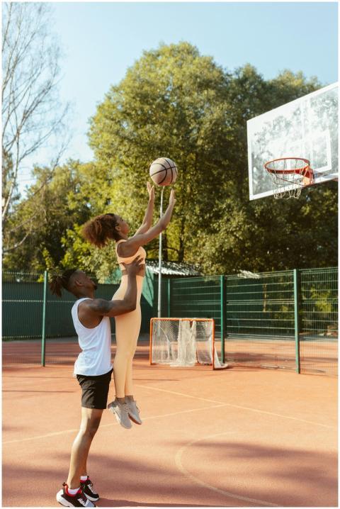 Two athletes practice basketball shots outdoors on