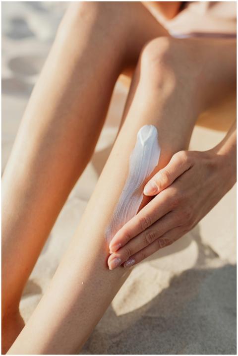 Close-up of a woman applying sunscreen on her legs
