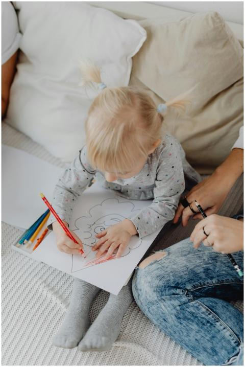 Adorable child coloring with colored pencils on a