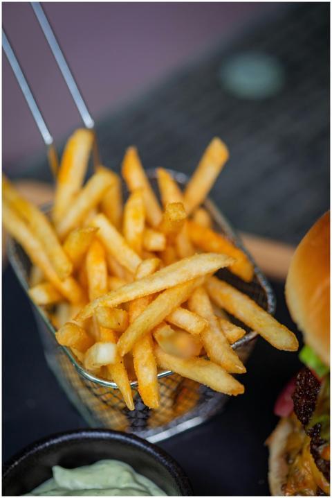 Close-up of crispy french fries in a metal basket,