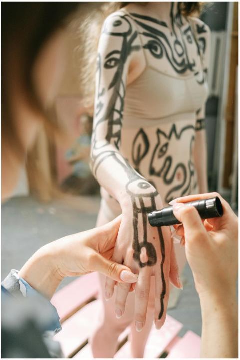 Artist painting abstract designs on a model's skin