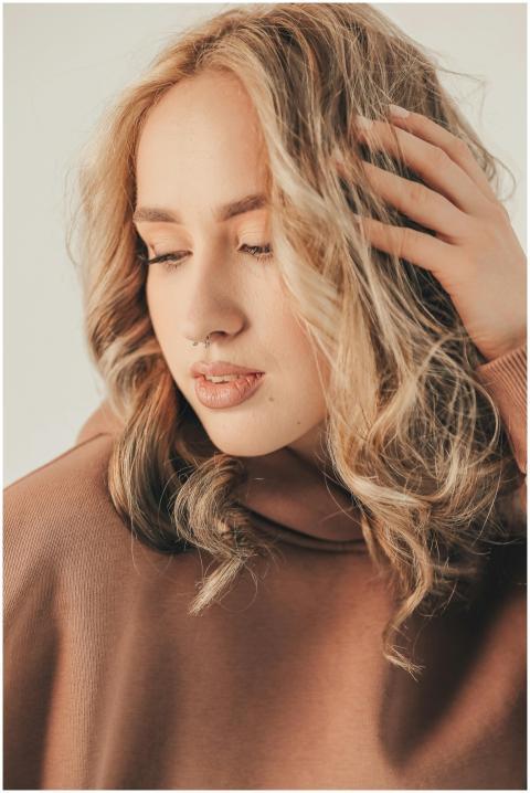 A close-up portrait of a blonde woman in a cozy br