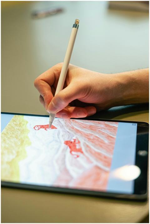 Close-up of hand drawing on tablet screen with sty